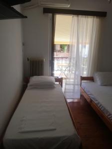 two beds sitting in a room with a window at Penelope -Πηνελόπη in Loutra Edipsou +47 photos