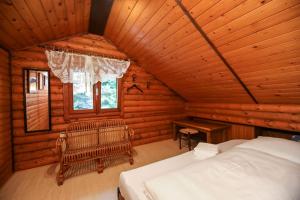a bedroom in a log cabin with a bed and a desk at Blockhaus Edelsberg in Sebersdorf