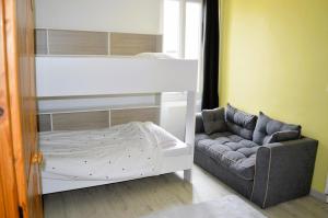 - une chambre avec des lits superposés et un canapé dans l'établissement Halte Lutine - Maison chaleureuse en pierres, à Luc-sur-Mer
