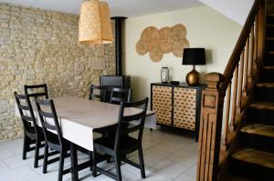 - une salle à manger avec une table et des chaises dans l'établissement Halte Lutine - Maison chaleureuse en pierres, à Luc-sur-Mer