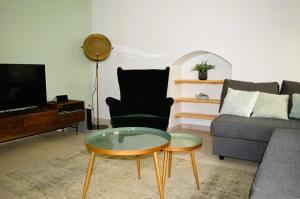 - un salon avec un canapé et une table dans l'établissement Halte Lutine - Maison chaleureuse en pierres, à Luc-sur-Mer