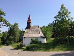a small church with a steeple on the side of a road at Ferienwohnung Gut Eschlsaign in Arrach