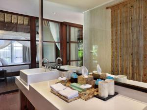 a bathroom with a sink and a counter with towels at Novotel Lombok Resort & Villas in Kuta Lombok