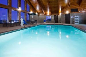 a large swimming pool with blue water in a building at AmericInn by Wyndham Osceola in Osceola