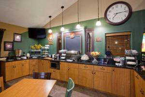 a large kitchen with a large clock on the wall at AmericInn by Wyndham Osceola in Osceola