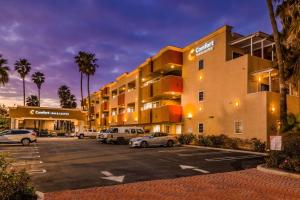 un parking avec des voitures garées devant un hôtel dans l'établissement Comfort Inn & Suites Huntington Beach, à Huntington Beach