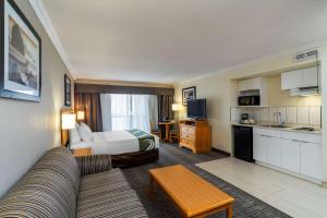 a large hotel room with a bed and a kitchen at Quality Inn Downtown Inner Harbour in Victoria