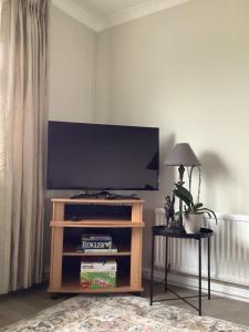 a flat screen tv on a entertainment center in a living room at Mullaghmeen Forest in Mullingar