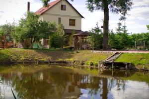 una casa junto a un río con una casa en Slavyanskiy Club, en Poltava