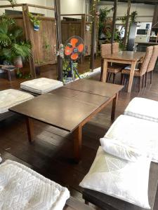 uma mesa de madeira e cadeiras num quarto em ゲストハウス303 em Zamami