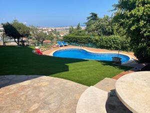 a swimming pool in the middle of a yard at Kornelijas House in Santa Susanna