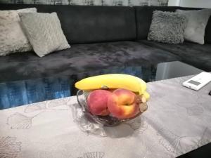 a bowl of fruit on a table with a banana at Апартамент ЗАПАД in Kazanlŭk