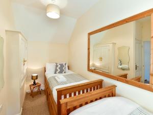 a bedroom with two beds and a mirror at Pass the Keys Cosy Rural 2 Bed Barn conversion close to Beach 