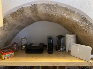 a shelf with a coffee maker and a coffeemaker at NEFELI castle stone house inside the fortress in Monemvasia