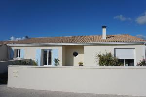 een wit hek voor een huis bij Chambre d'hôtes le Berceau in Meschers-sur-Gironde