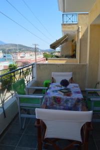 uma mesa e cadeiras numa varanda com vista em Mauve Apartment em Argostólion