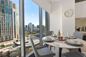 a dining room with a table and chairs and a clock at Sophisticated Designer Condo W River & City Views in Melbourne +11 photos