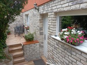 a brick house with a patio with flowers in a window at Ubytovanie na sukromí in Banská Štiavnica