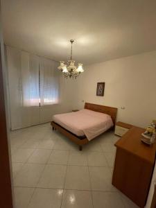 1 dormitorio con cama y lámpara de araña en Casa Milano - Sottomarina, en Sottomarina