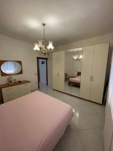 a bedroom with a white bed and a mirror at Casa Milano - Sottomarina in Sottomarina +5 photos
