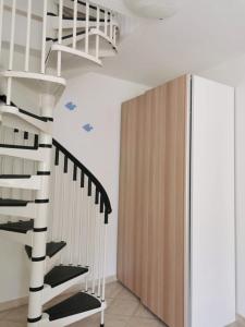 una scala in un soggiorno con scala bianca e nera di Casa Gaia a Golfo Aranci