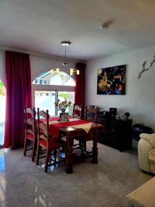 Un comedor con una mesa y sillas rojas. en Casa Bella, en Mijas Costa