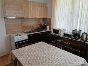 a small kitchen with a table and a stove at Къща за гости - Софи, гр. Девин in Devin