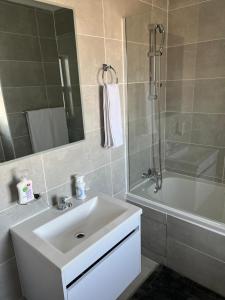 La salle de bains est pourvue d'un lavabo, d'une douche et d'une baignoire. dans l'établissement Sarona City L203, à Gaborone