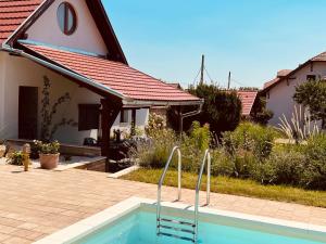a swimming pool in front of a house at GouldVilla Vendégház in Villány