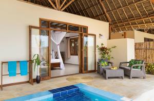 a villa with a pool and a bedroom at Zanzibar Queen Hotel in Matemwe