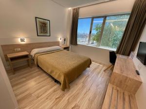 Una habitación de hotel con una cama y una ventana. en Hotel Concordy, en Madrid 37 fotos más
