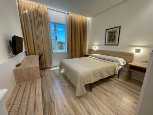 Una habitación de hotel con una cama y una ventana. en Hotel Concordy, en Madrid
