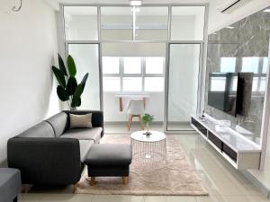 a living room with a couch and a tv at Ani's House- 3 Bedroom Apartment at Pangsapuri Ladang Tanjung in Kuala Terengganu