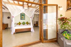 a room with a bed and a glass door at Zanzibar Queen Hotel in Matemwe