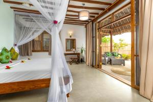 a bedroom with a bed with a mosquito net at Zanzibar Queen Hotel in Matemwe