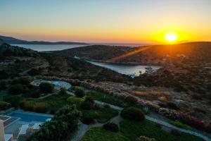 uma vista aérea de um resort com o pôr-do-sol em Schinoza Luxury Suites em Skhoinoussa
