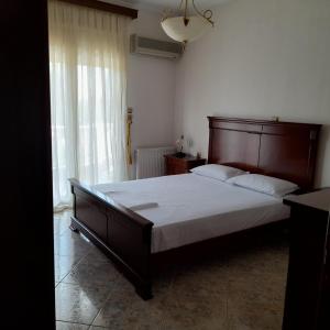 a bedroom with a large bed with a wooden headboard at Villa St.George in Katerini