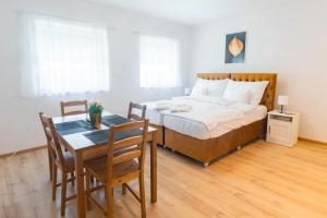 sypialnia z łóżkiem, stołem i krzesłami w obiekcie Villa Lilith Smart w mieście Fertőrákos +37 zdjęć