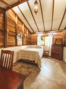 a bedroom with a bed in a room with wooden walls at Casa Papaki in Mérida