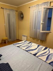 a bedroom with a large bed with a window at Apartman Nina in Kotor