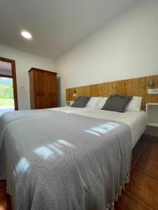 um quarto com uma grande cama branca num quarto em Apartamento familiar cercano a playa de Rodiles 1 em Selorio