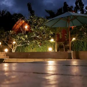 a patio with an umbrella and lights at night at Light Blue Villa in Tepus