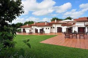 a house with a patio with tables and umbrellas at Apartamento familiar cercano a playa de Rodiles. 7 in El Olivar +16 photos