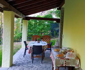 a patio with a table and chairs with food on it at B&B Il Ghiro in Riolunato
