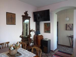 a dining room with a table and a television on the wall at Calabria Melia di Scilla collina Antico Casale con giardino bio naturale in Castagnarella