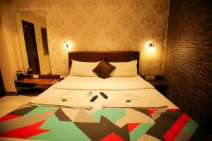 een slaapkamer met een groot bed en een kleurrijk dekbed bij Hotel Garden Creek Residency - Near Mumbai International Airport Andheri East in Mumbai