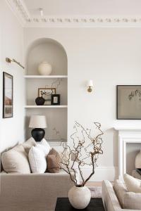 ein Wohnzimmer mit einem Sofa und einem Baum in einer Vase in der Unterkunft The Paragon, Bath in Bath