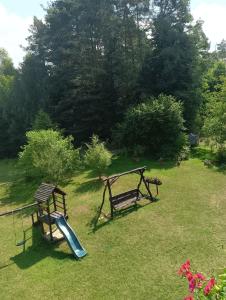 a playground with two benches and a slide at Wynajem pokoi WIKI in Mikołajki