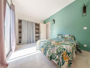 a bedroom with green walls and a bed with a colorful bedspread at Fully renovated house only few minutes walk away from Ohama Beach in Vierville-sur-Mer