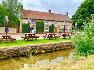 een groep picknicktafels voor een gebouw bij Peaceful Country Cottage - views/walks - New 2022 in Lincoln